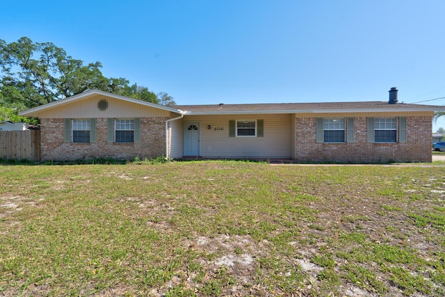 ranch-style house featuring a front yard, brick siding, and fence