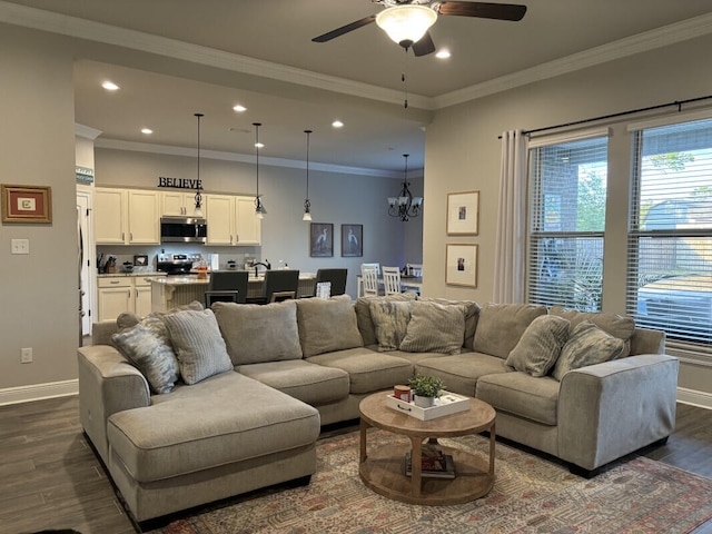 living area with dark wood finished floors, baseboards, ceiling fan with notable chandelier, and recessed lighting