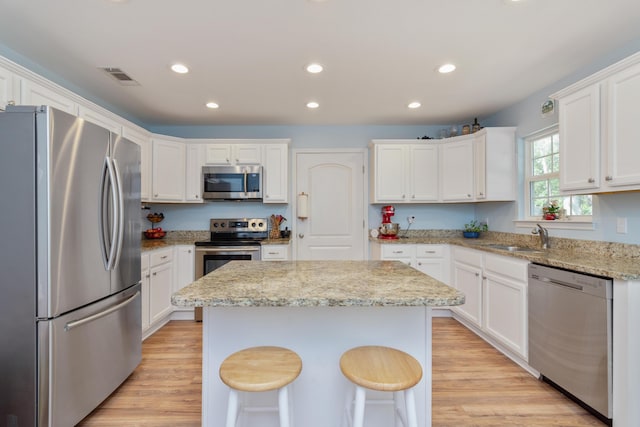 511 Oak Ave, Niceville, FL 32578 - kitchen featuring appliances with stainless steel finishes, a sink, a center island, recessed lighting, and white cabinetry