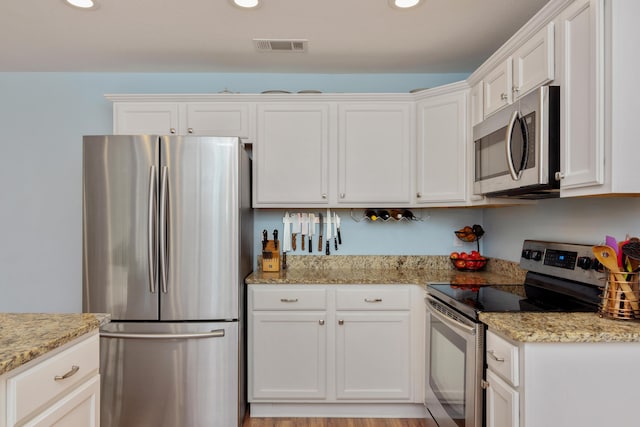 511 Oak Ave, Niceville, FL 32578 - kitchen with appliances with stainless steel finishes, white cabinetry, recessed lighting, and light stone counters