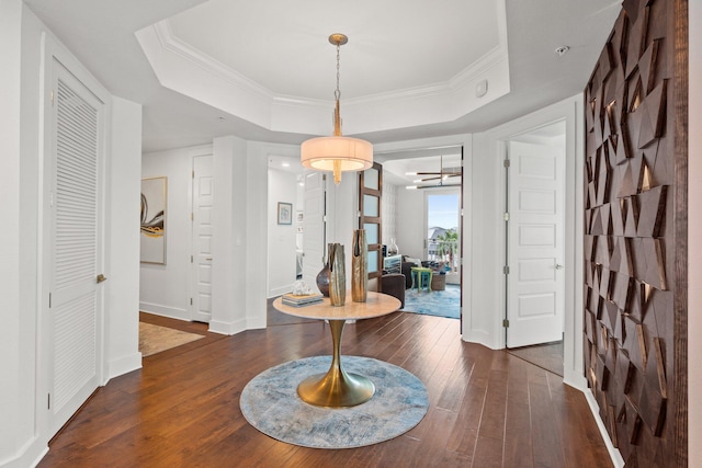 entryway featuring crown molding, baseboards, a raised ceiling, and hardwood / wood-style flooring