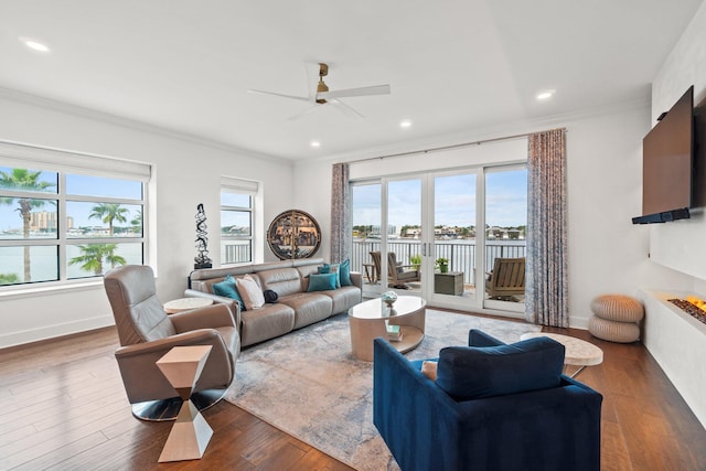 living area with ceiling fan, ornamental molding, wood finished floors, and recessed lighting