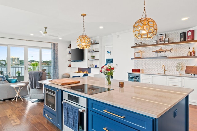 kitchen with open floor plan, dark wood-type flooring, blue cabinetry, black electric cooktop, and oven