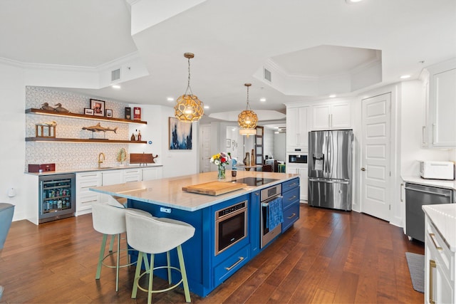 kitchen featuring a tray ceiling, stainless steel appliances, white cabinets, blue cabinets, and wine cooler