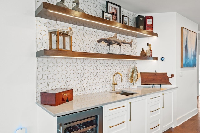 bar featuring a sink, indoor wet bar, wine cooler, dark wood finished floors, and decorative backsplash
