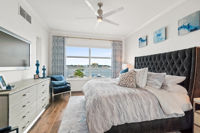 bedroom with crown molding, ceiling fan, visible vents, and wood finished floors