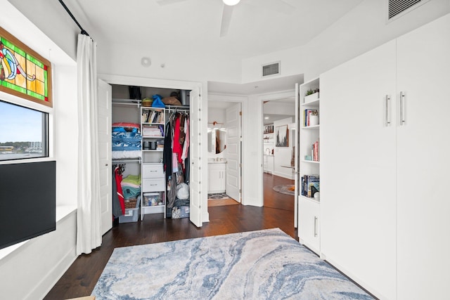 bedroom with a closet, visible vents, wood finished floors, and a ceiling fan