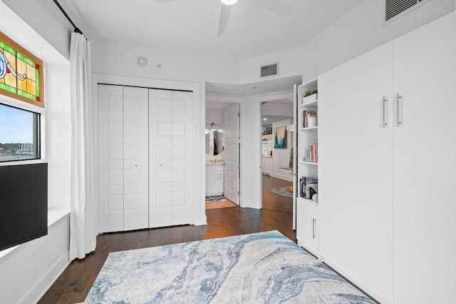 bedroom with connected bathroom, visible vents, a ceiling fan, and dark wood-type flooring