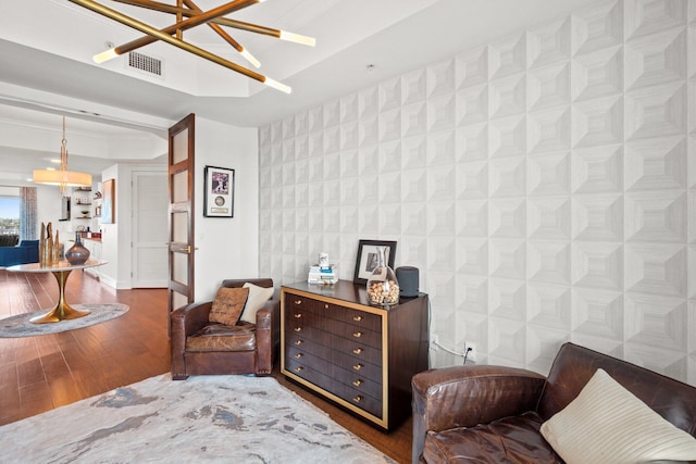 sitting room with hardwood / wood-style flooring, baseboards, visible vents, a notable chandelier, and wallpapered walls