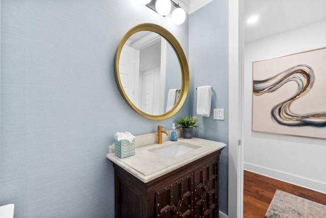 bathroom with vanity, wood finished floors, and baseboards