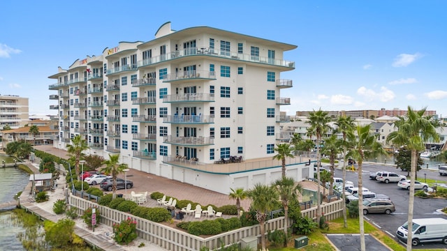 view of building exterior featuring uncovered parking and a water view