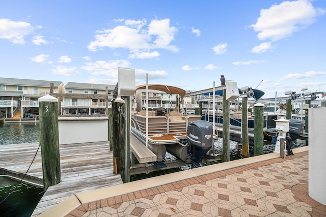 view of dock with a water view, a residential view, and boat lift