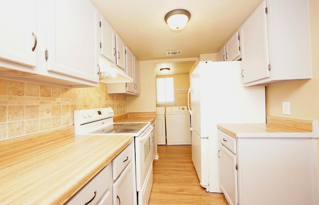 kitchen featuring washer and dryer, white cabinetry, visible vents, white appliances, and under cabinet range hood