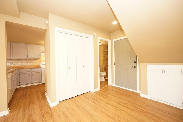 additional living space featuring baseboards and light wood-style floors