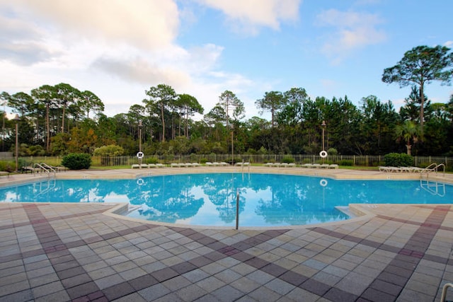 897 Cocobolo Dr, Santa Rosa Beach, FL 32459 - community pool with a patio, fence, and view of wooded area
