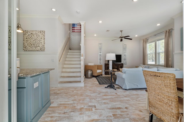 living area with ceiling fan, stairway, ornamental molding, and recessed lighting