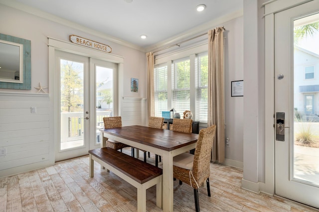 dining area with wainscoting, french doors, light wood-style flooring, and plenty of natural light