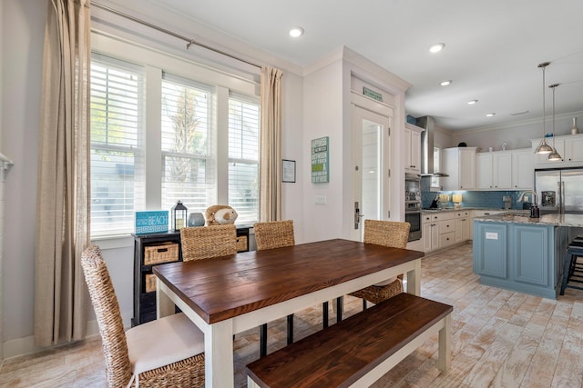 dining space featuring recessed lighting, light wood-style floors, crown molding, and plenty of natural light