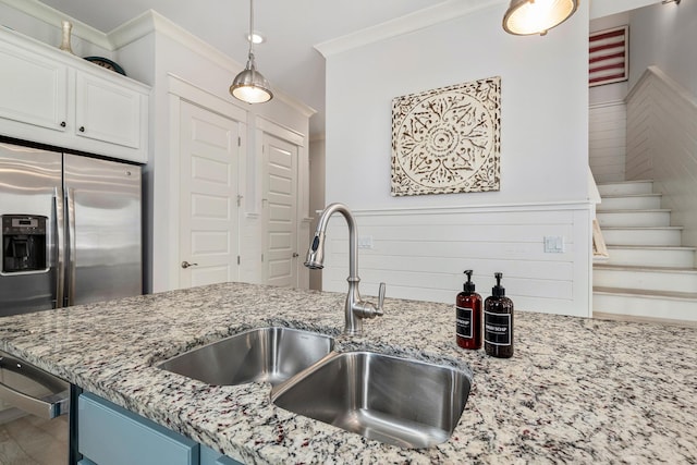 kitchen with light stone countertops, a sink, white cabinetry, stainless steel fridge with ice dispenser, and crown molding