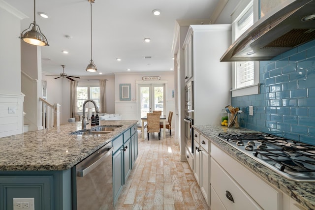 kitchen featuring a sink, ventilation hood, decorative light fixtures, appliances with stainless steel finishes, and tasteful backsplash