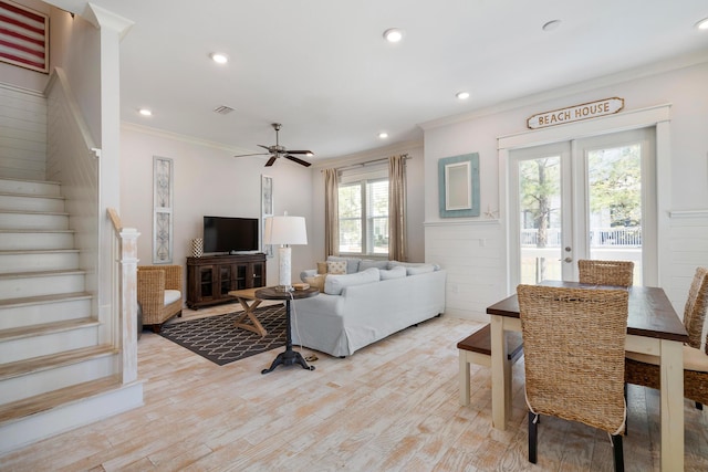 living room featuring ornamental molding, stairs, and light wood-type flooring