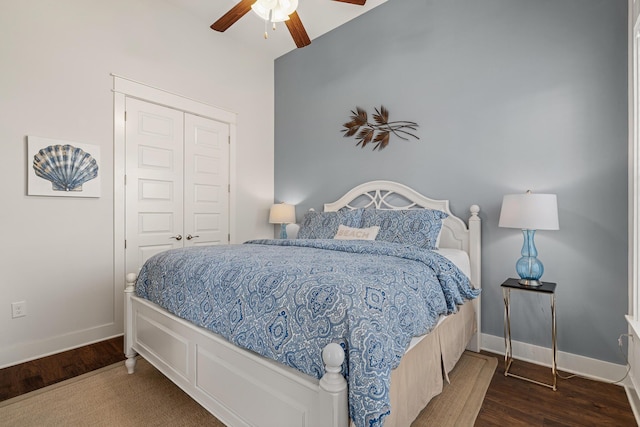 bedroom with a closet, a ceiling fan, wood finished floors, and baseboards