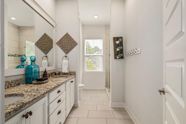 full bath featuring a sink, toilet, double vanity, baseboards, and a tile shower