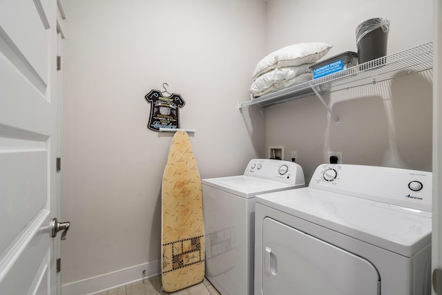 washroom with separate washer and dryer, laundry area, and baseboards
