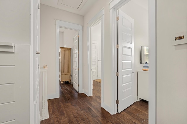 hallway featuring baseboards and dark wood-style floors