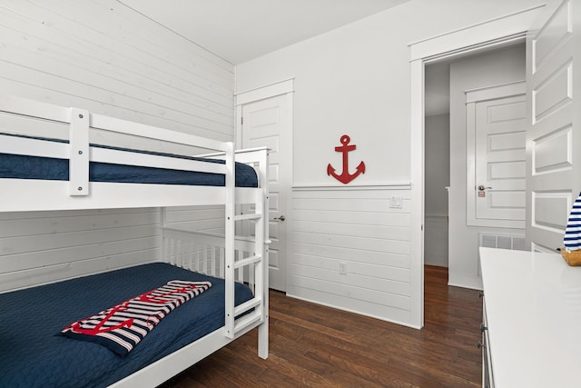 bedroom featuring wood walls and wood finished floors