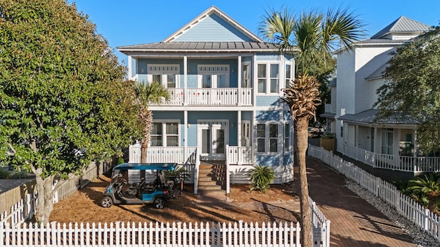 91 Stingray St, Destin, FL 32541 - view of front facade featuring fence private yard, metal roof, a standing seam roof, and a balcony