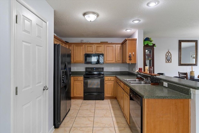 291 Dahlquist Dr, Crestview, FL 32539 - kitchen with black appliances, a sink, dark countertops, a peninsula, and a textured ceiling