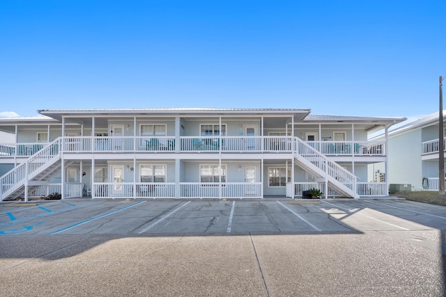 view of property with uncovered parking and stairs