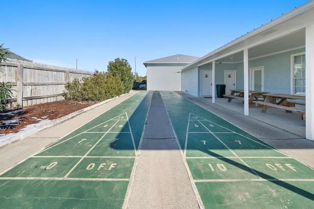 view of property's community with shuffleboard and fence