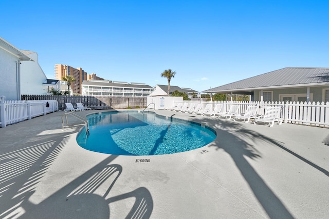 community pool featuring a patio and a fenced backyard