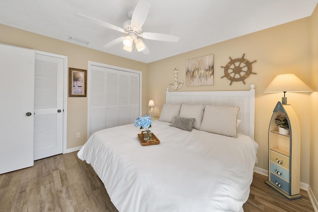 bedroom with baseboards, visible vents, a ceiling fan, and wood finished floors