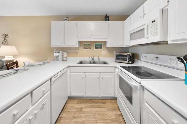 kitchen featuring light wood-style flooring, a sink, a toaster, white appliances, and light countertops