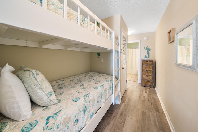 bedroom with wood finished floors and baseboards