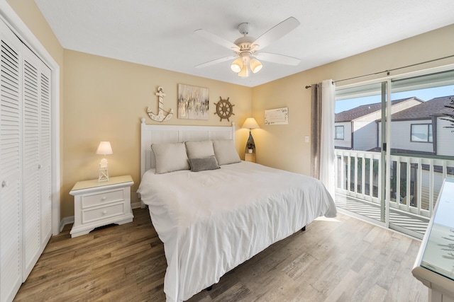 bedroom with a ceiling fan, a closet, baseboards, wood finished floors, and access to exterior