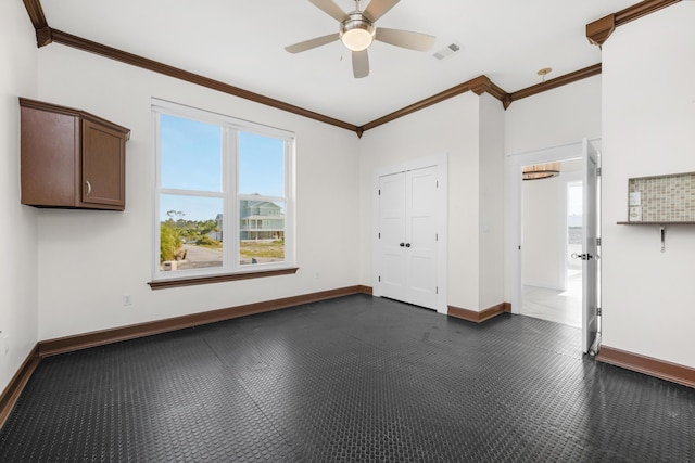 empty room featuring crown molding, baseboards, and a ceiling fan