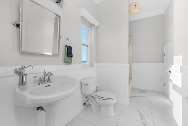 full bath featuring marble finish flooring, a wainscoted wall, toilet, ornamental molding, and a shower