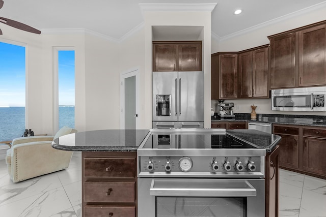 kitchen with high end appliances, light marble finish flooring, a ceiling fan, dark brown cabinetry, and dark stone countertops