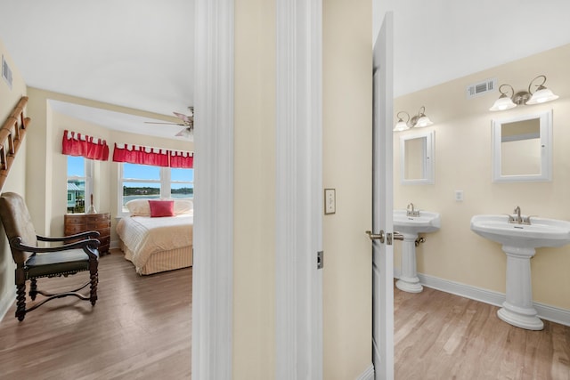 bathroom featuring wood finished floors, baseboards, connected bathroom, ceiling fan, and a sink