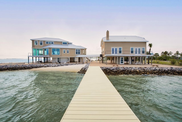 dock area with a water view and a balcony
