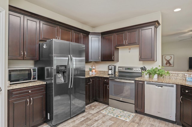 kitchen featuring light stone counters, recessed lighting, dark brown cabinetry, light wood-style flooring, and appliances with stainless steel finishes