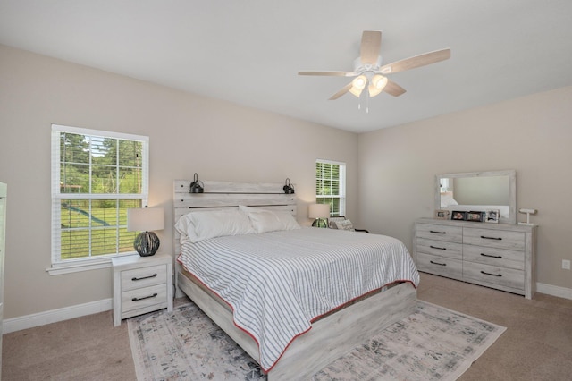 bedroom with baseboards, ceiling fan, and light colored carpet