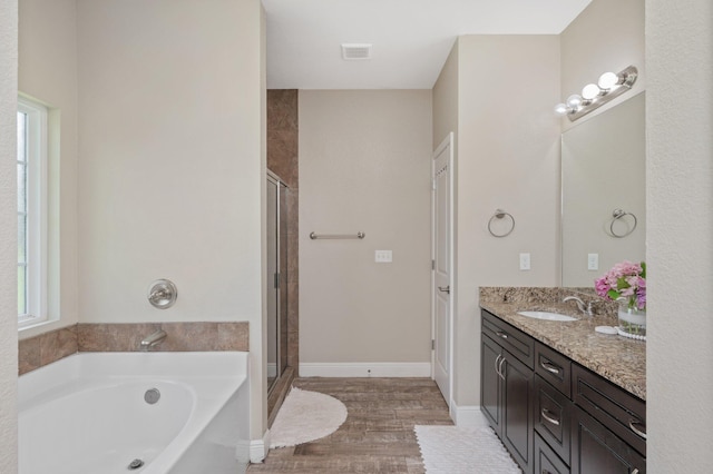 full bathroom featuring baseboards, a bath, a shower stall, vanity, and wood finished floors