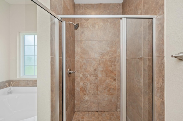 bathroom with a shower stall and a bath