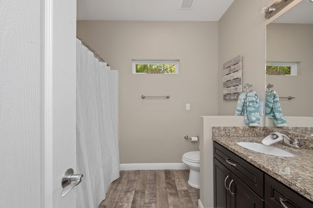 bathroom with toilet, wood finished floors, vanity, visible vents, and baseboards