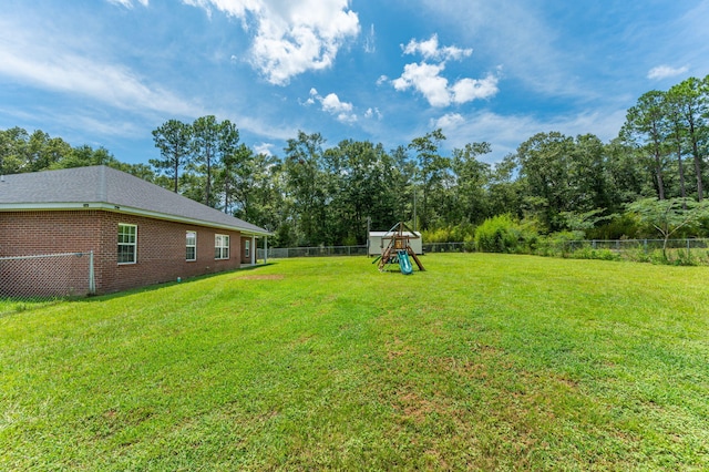 view of yard with a playground and a fenced backyard